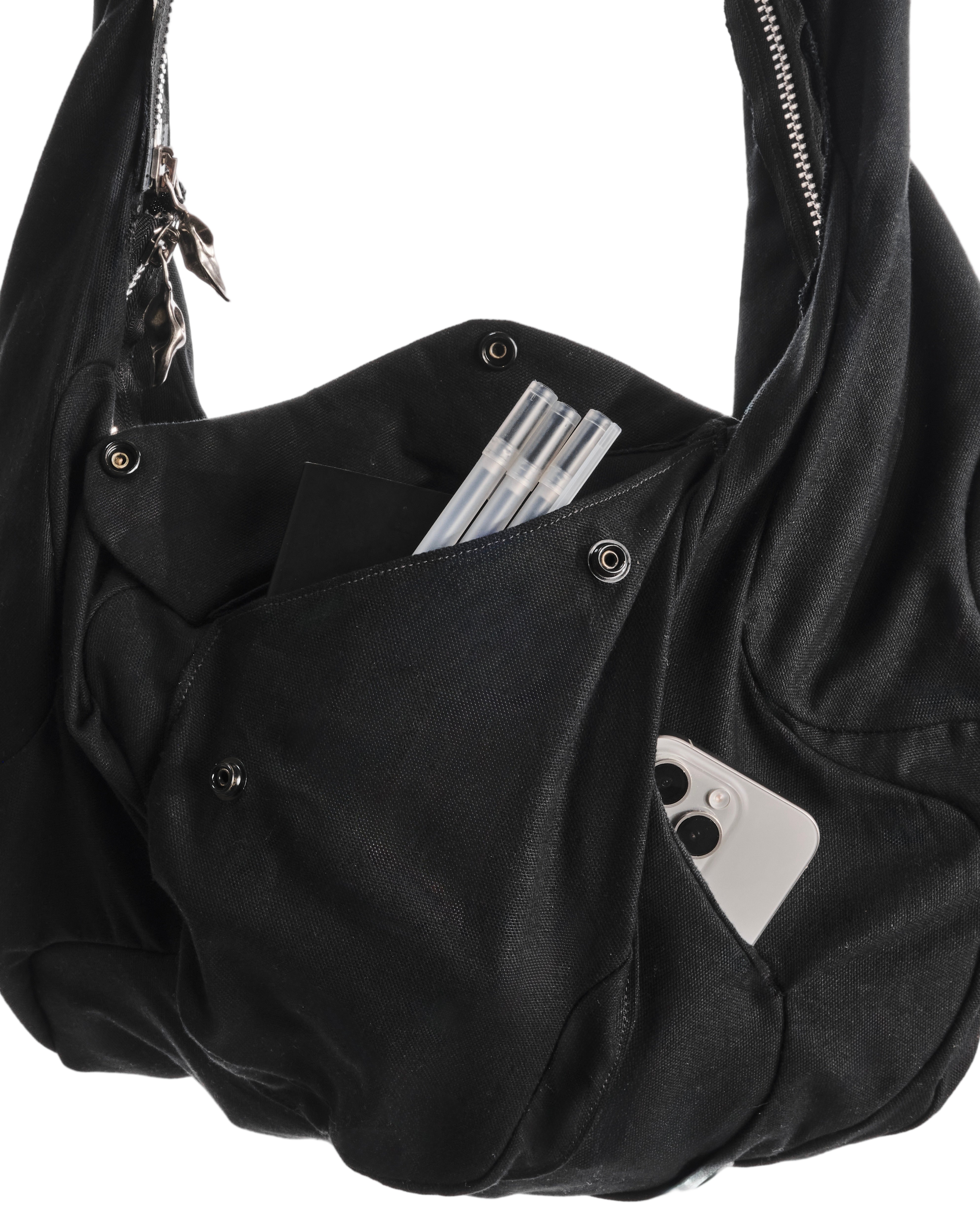 Black shoulder bag with a phone and money inside on a white background