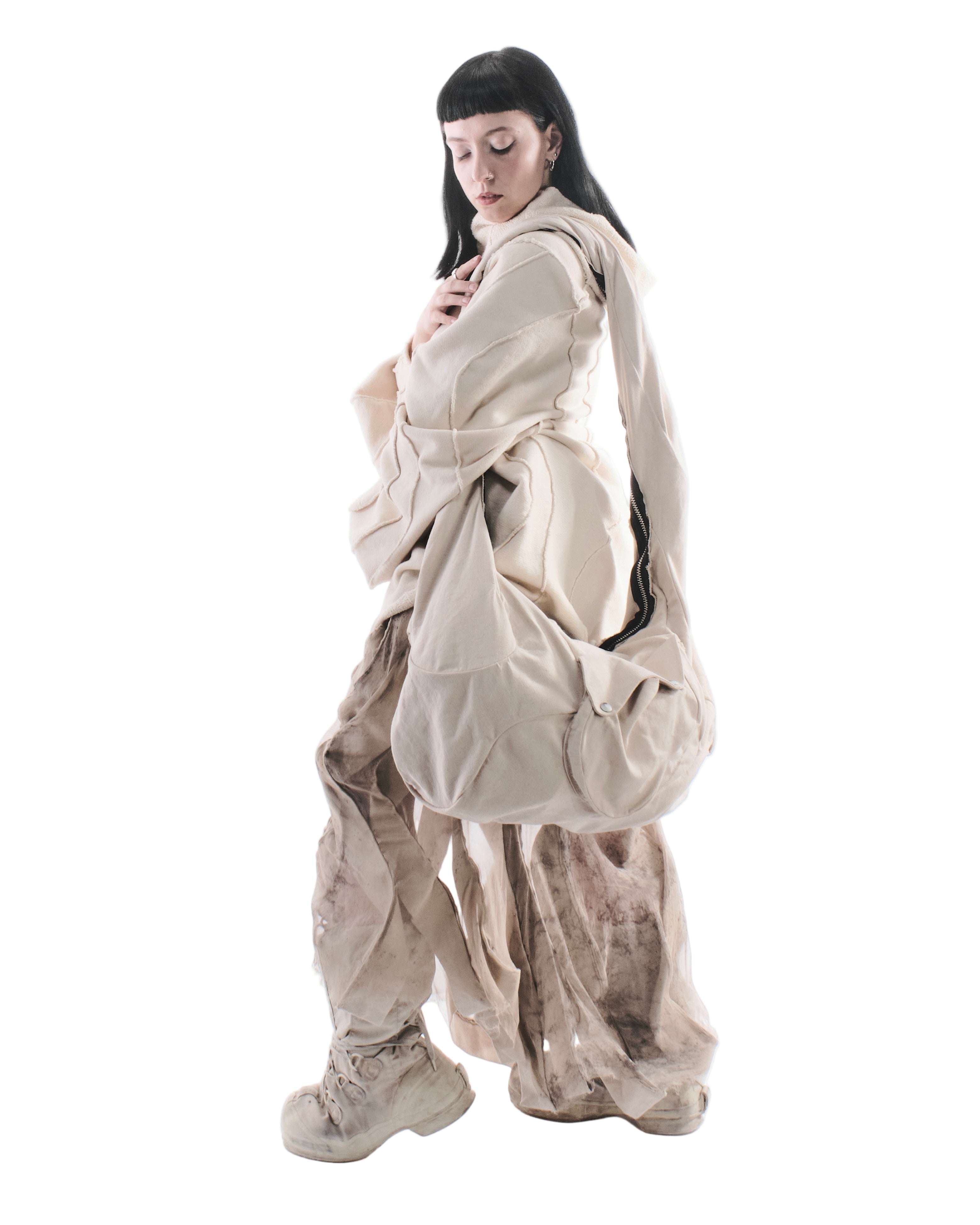 Person wearing a beige outfit with a white background