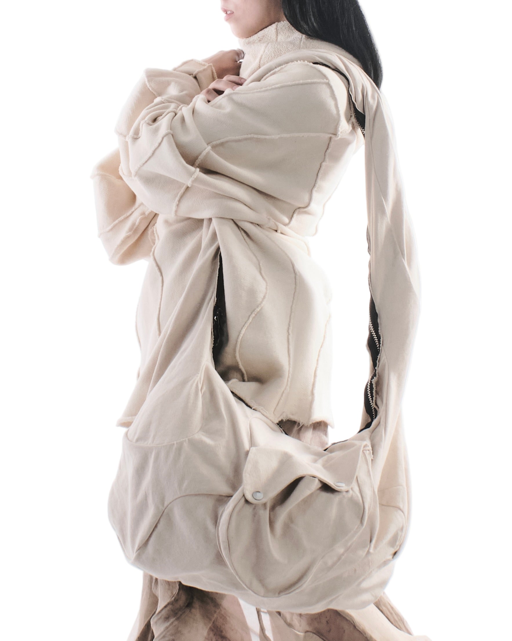 Person wearing a beige outfit with a unique design on a white background