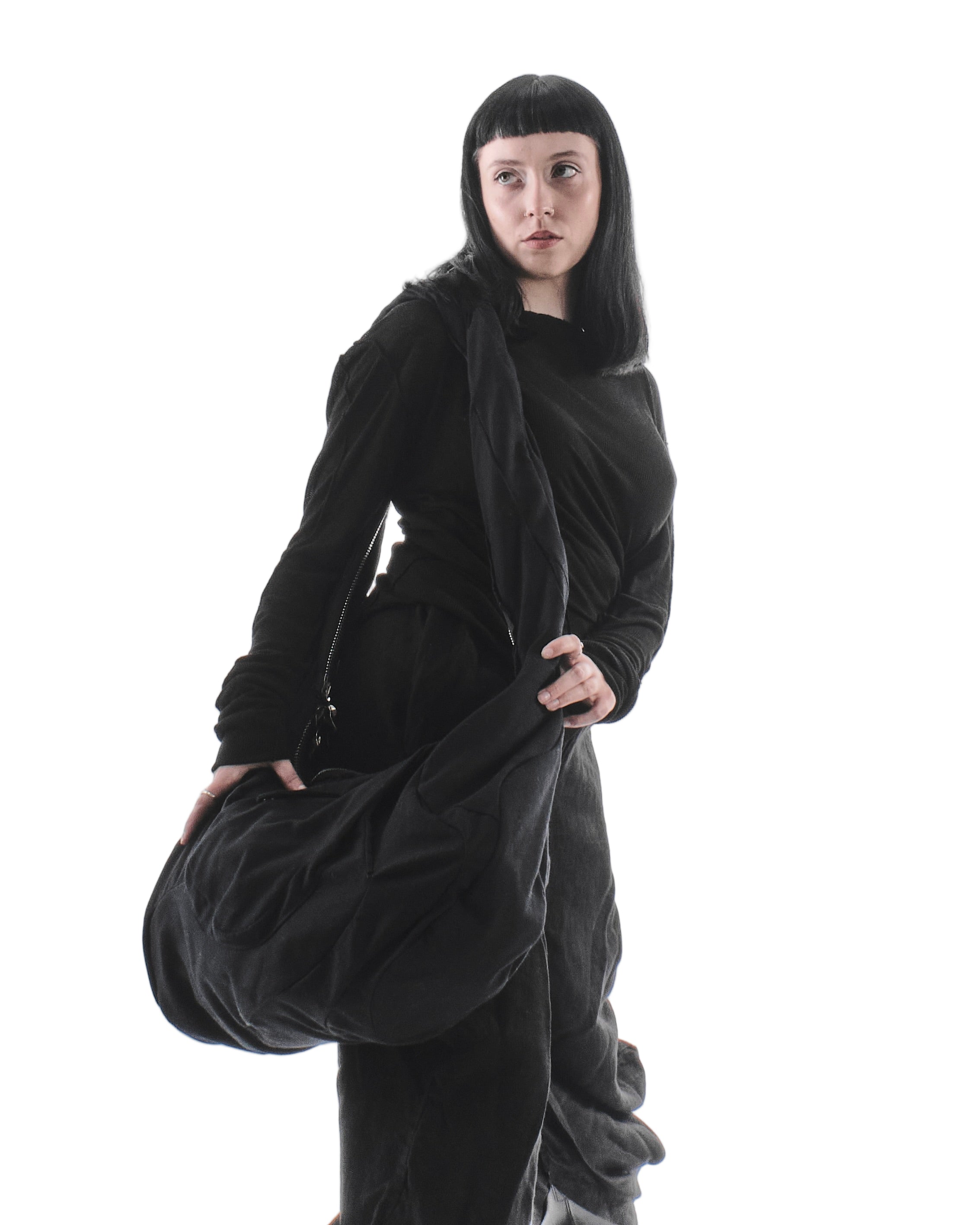 Person wearing a black outfit with a flowing garment on a white background