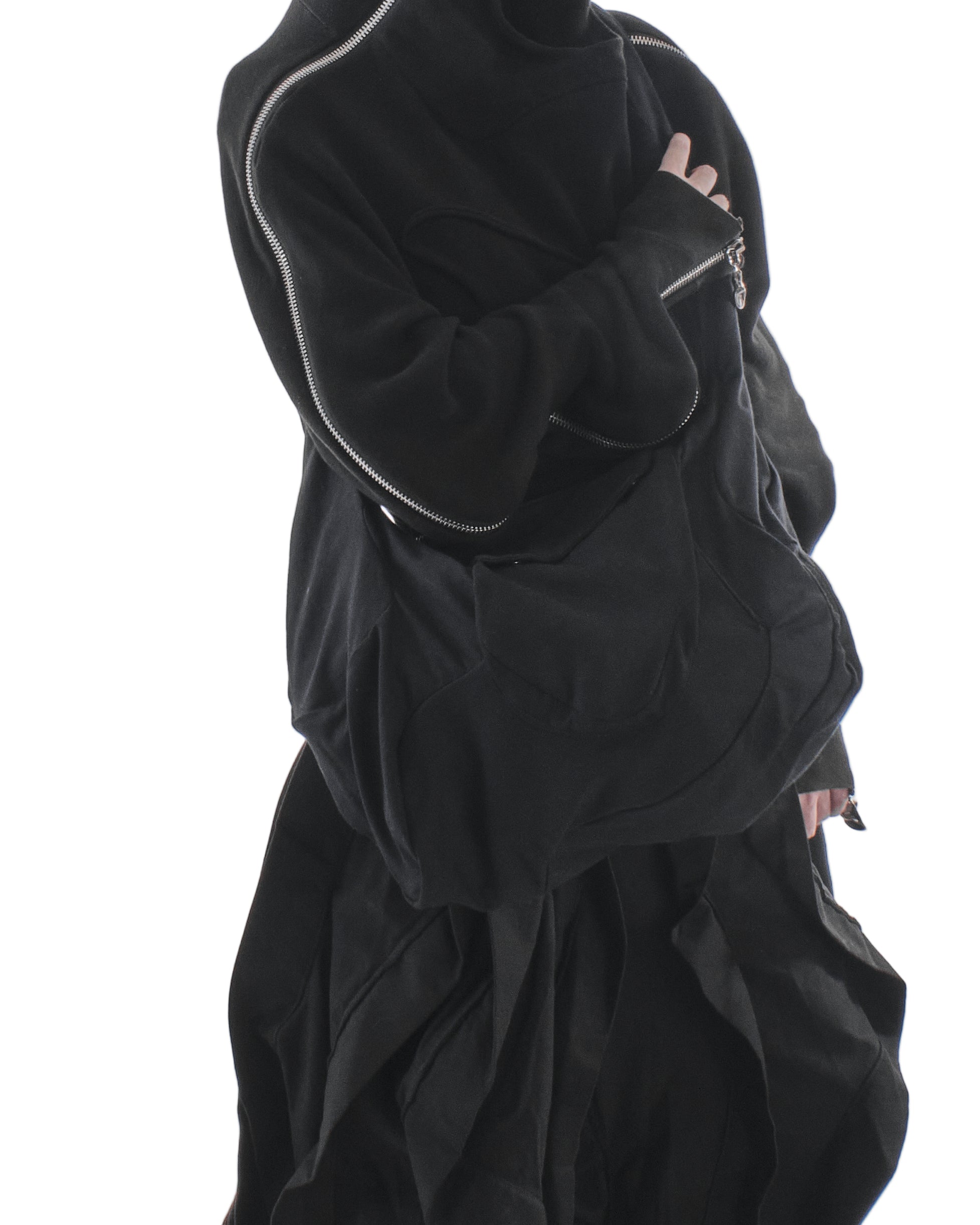 Person wearing a black outfit with a hood on a white background