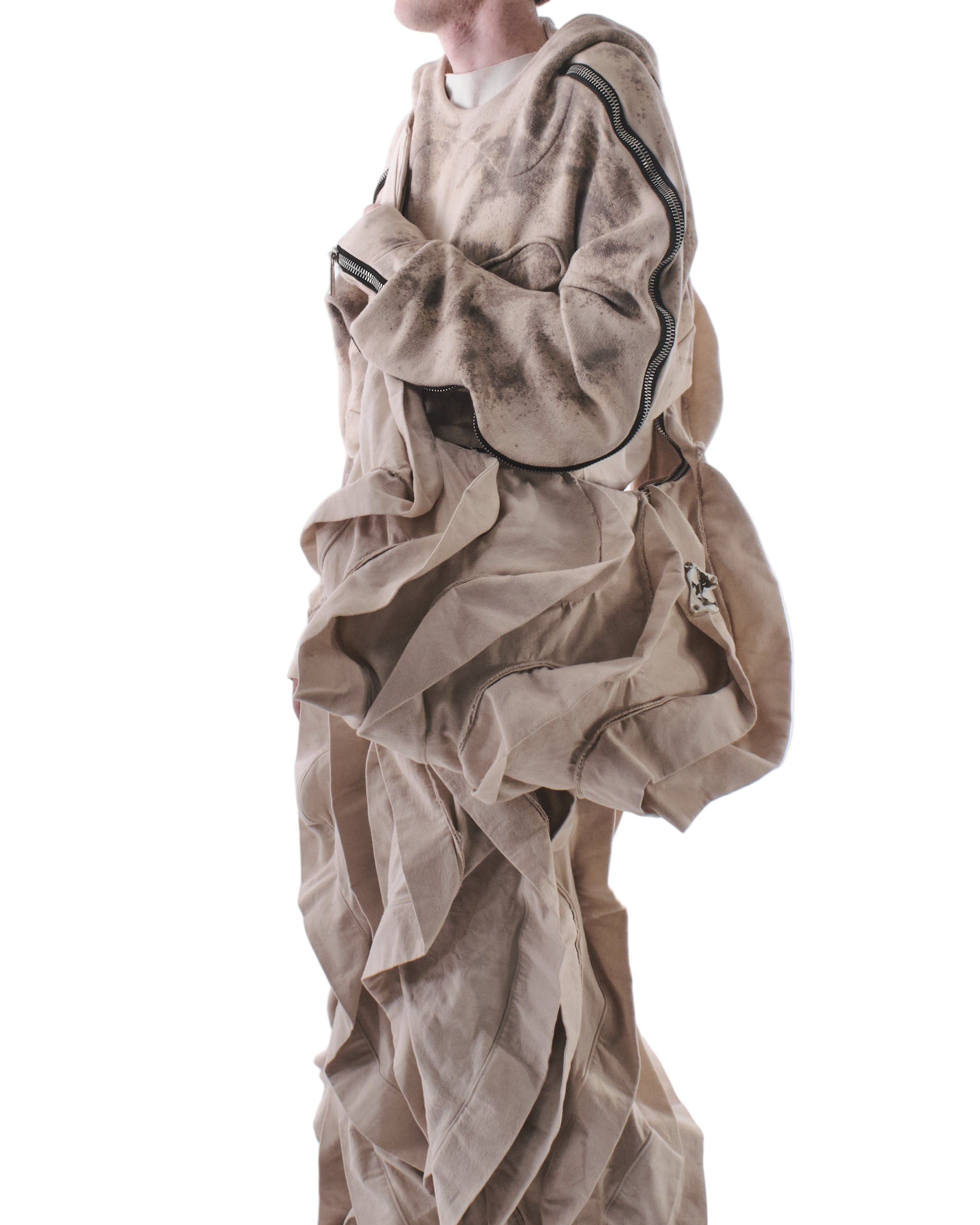 Person wearing a beige outfit with a bag over their head on a white background