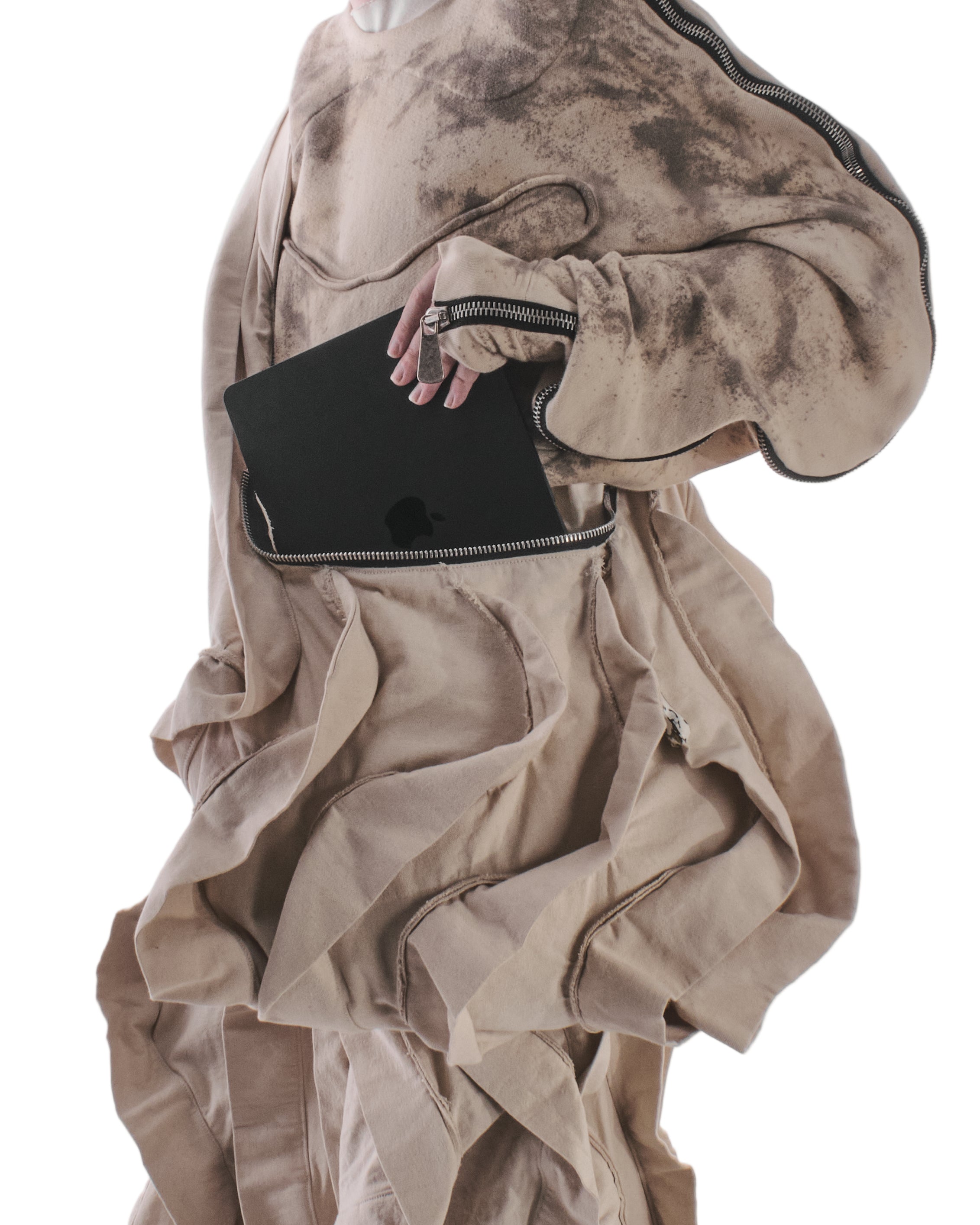 Person wearing a beige, textured dress with a black clutch on a white background